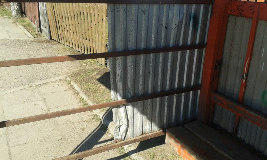 INTERWENCJA: Wybite szyby, wystająca blacha, brak desek. 